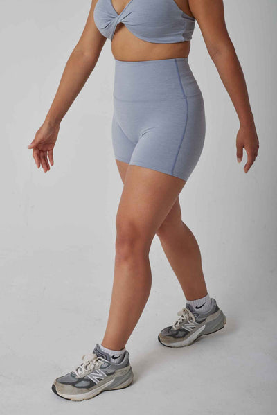 A women modeling grey high waisted active shorts perfect for weight training or pilates