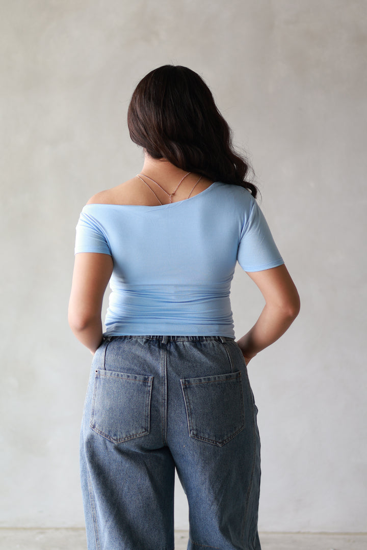 the back of a blue off the shoulder basic top