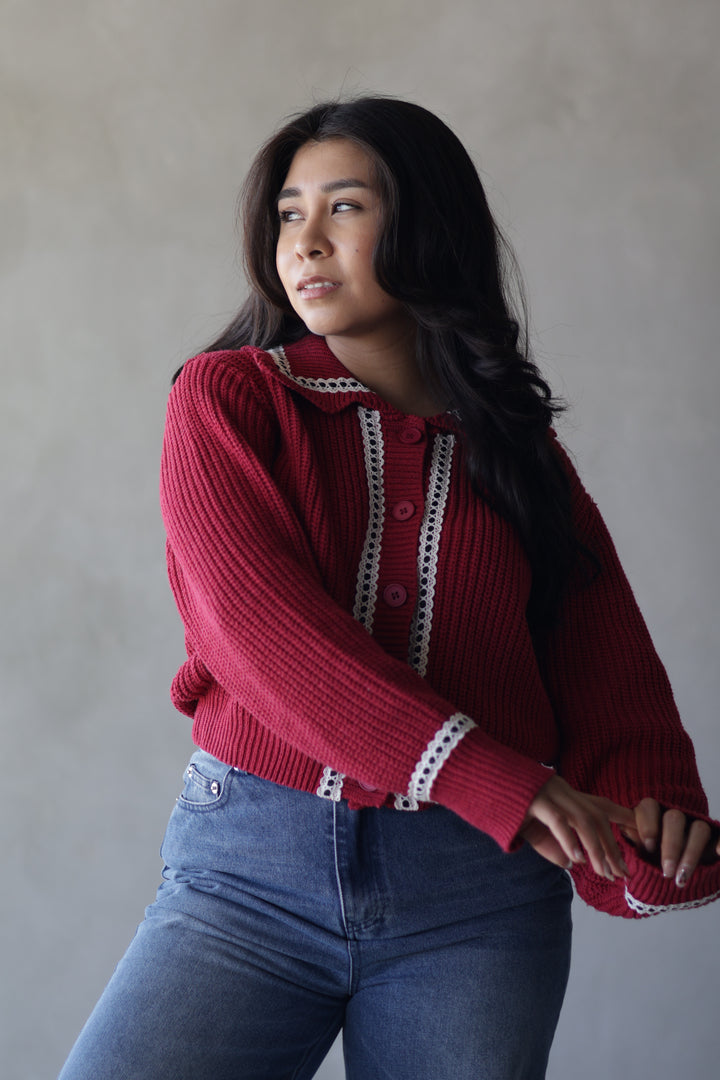 red knit cardigan with buttons going down and lace trim on neck line and on side of buttons 