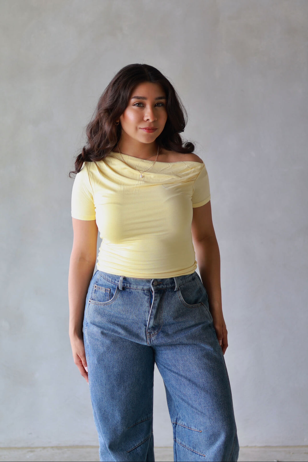 buttery yellow off the shoulder top paired with dark demim barrel jeans for women