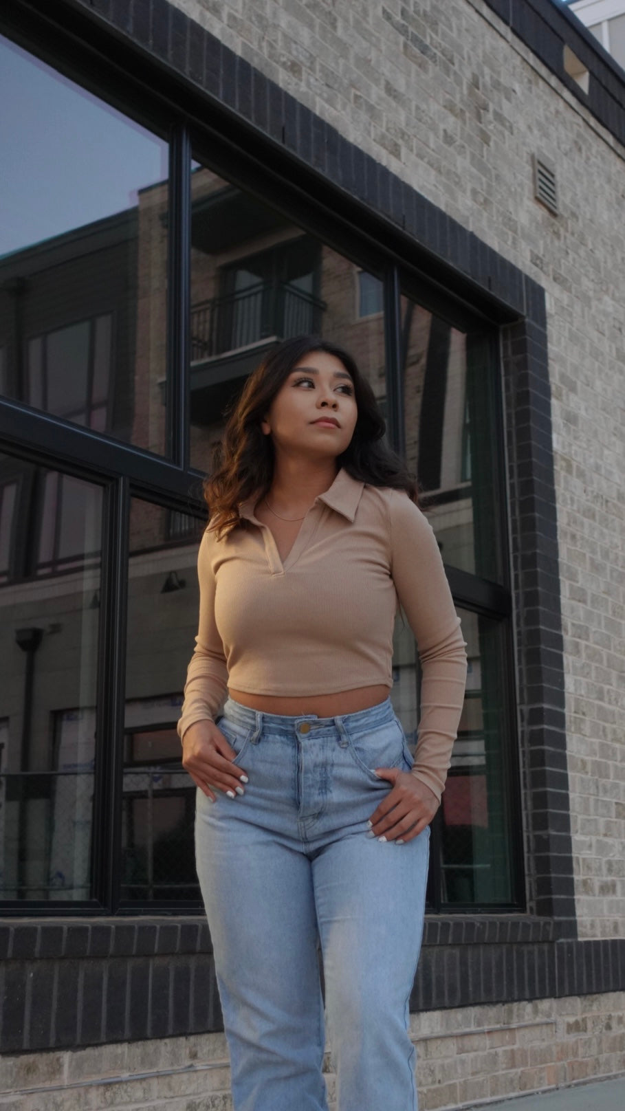  tan collared long-sleeve top paired with light washed jeans